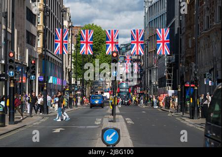 LONDON - May 18, 2022: Union Jack flags hanging above busy street for London Jubilee celebration Stock Photo