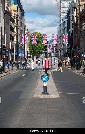 LONDON - May 18, 2022: Union Jack flags hanging above busy London street for Platinum Jubilee celebration Stock Photo