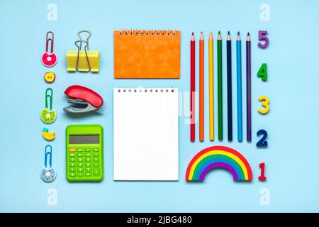 Frame from school and office supplies Paper clips, pens, calculator, sharpener, notepad, stapler isolated on blue background Flat lay Top view Back to Stock Photo