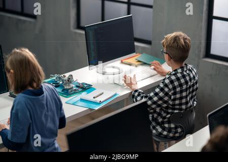 High angle view of school kids using computer in classroom at school Stock Photo