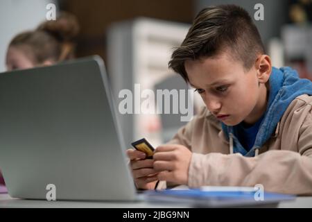 Schoolboy using computer in classroom at school Stock Photo