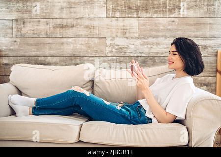 Smiling young girl purchases online using phone Stock Photo