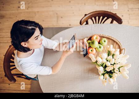 Smiling young girl purchases online using phone Stock Photo