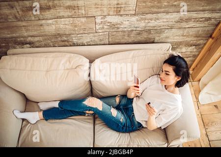 Smiling young girl purchases online using phone Stock Photo