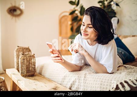 Smiling young girl purchases online using phone Stock Photo