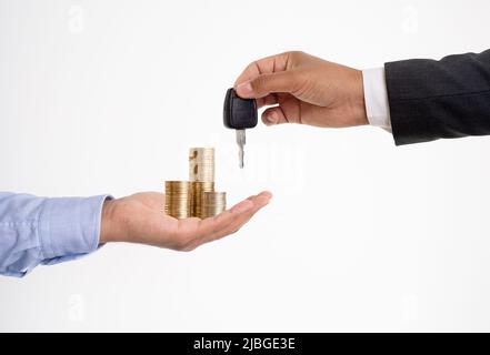 Close up photo of hands exchanging money and car key on isolated background. Stock Photo