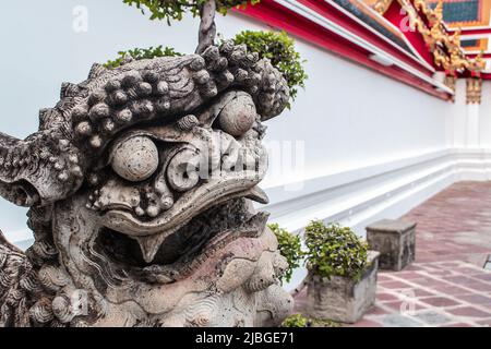 Wat Pho, Bangkok, Thailand - Mar. 15, 2017:  The closeup image of Lion statue with Chinese architecture at Wat Pho, Bangkok Thailand. Stock Photo