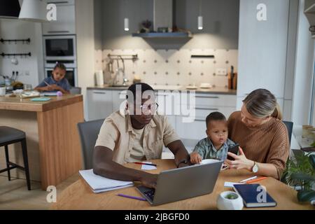 Portrait of multiethnic family with two children in casual home scene, copy space Stock Photo
