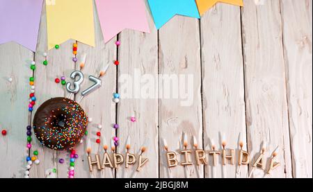 Birthday with number. Donut on the festive table. Happy birthday congratulations top view. Happy birthday card with beautiful decorations on a white Stock Photo