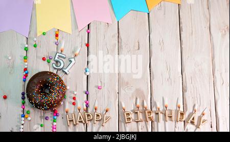 Birthday with number. Donut on the festive table. Happy birthday congratulations top view. Happy birthday card with beautiful decorations on a white Stock Photo