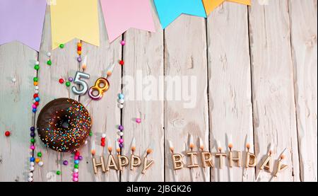 Birthday with number. Donut on the festive table. Happy birthday congratulations top view. Happy birthday card with beautiful decorations on a white Stock Photo