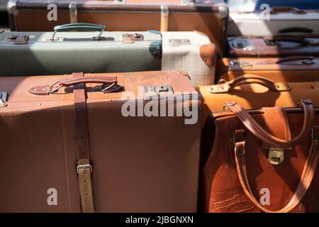 Old suitcases in all shapes and sizes for sale at a sunny flea market in Maastricht Stock Photo