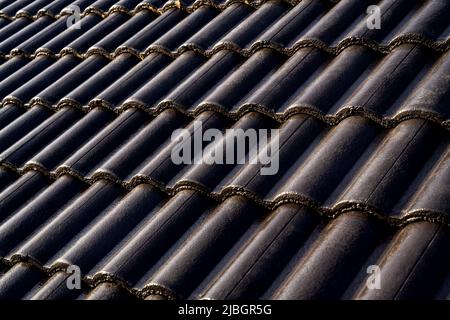 Concrete roof tiles. Dark Brown Tiles Color on new roof construction. Stock Photo