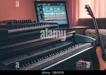Electronic piano and guitar in room interior. Stock Photo