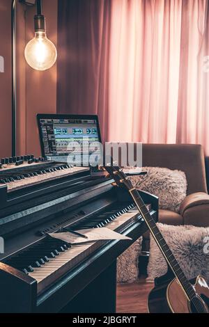 Electronic piano and guitar in room interior. Stock Photo