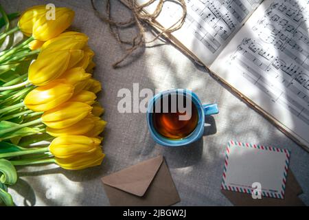 Vintage composition with a cup of tea, tulips and notes, flat lay. Stock Photo