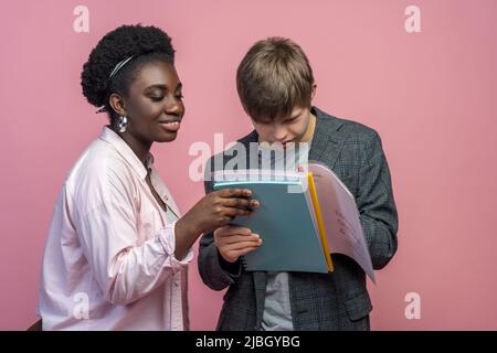Guy reading notebook and woman watching approvingly Stock Photo