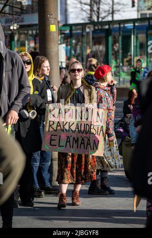 Kapinoin rakkaudesta elämään. Young woman holding a hand-written cardboard sign at Elokapina's Ylikulutuskapina demonstration in Helsinki, Finland. Stock Photo