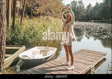 Woman practicing yoga on a landing stage Stock Photo