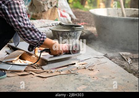 Worker using electric circular saw cutting granite tile in construction site Stock Photo
