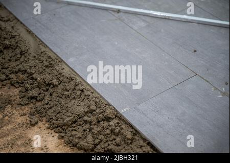 Tiled with gray granite tile on the floor in the bathroom Stock Photo