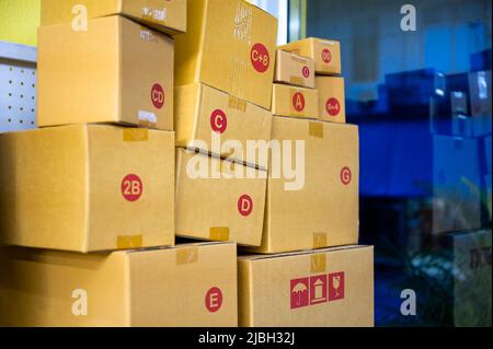 Different sizes brown cardboard box stacked in parcel delivery shop Stock Photo