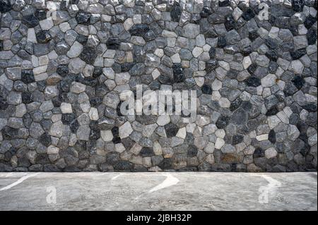 Exterior natural rugged stacked stone wall and cement floor Stock Photo