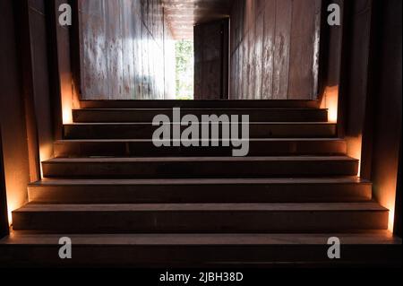 Rust staircase with lighting in abandoned metallic corridor and door opening at warehouse Stock Photo
