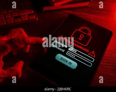 Weak password words on the screen in the dark. Stock Photo