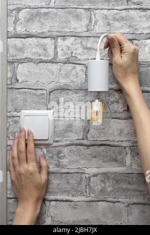 female hand holding a lamp on a wire Stock Photo