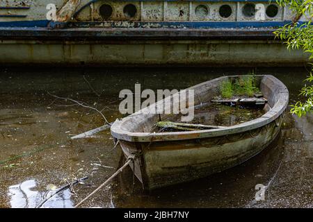 old rotten sunken boat tied to the shore Stock Photo