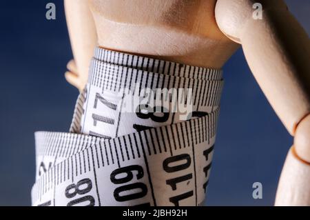 Wooden mannequin with measuring tape Stock Photo