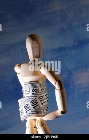 Wooden mannequin with measuring tape Stock Photo