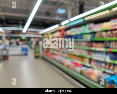 Grocery store blur bokeh background - shoppers at grocery store with defocused lights. Supermarket blurred background with bokeh, abstract blur and de Stock Photo