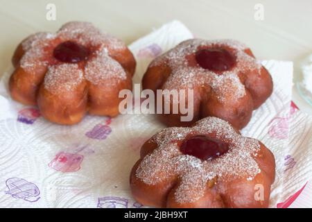 Donuts in powdered sugar. Donuts in the form of a flower, with jam. Close-up. Stock Photo