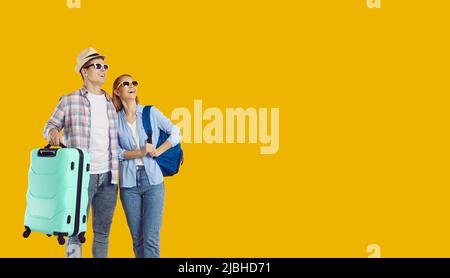 Happy young couple of travelers enjoy trip abroad on weekend and look at copy space with delight. Stock Photo