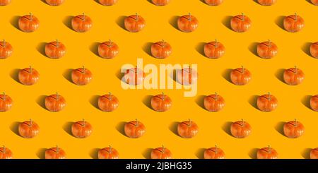Pumpkin pattern, decorative pumpkins on orange background top view. Autumn, fall, halloween concept. Trend shadow. Stock Photo
