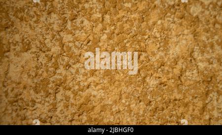High detailed abstract fragment of yellow drip wall background. Closed up of ocher color stone wallpaper. New stonewall urban texture Stock Photo