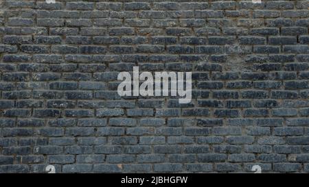 Horizontal part of dark brick wall background. Exterior wide old stone bricks texture for pattern. Home or office design backdrop Stock Photo