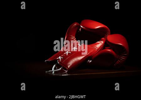 Red boxing gloves with laces on black background Stock Photo