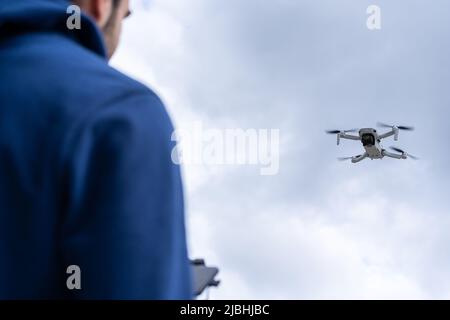 Young man with his back flying a drone outdoors Stock Photo
