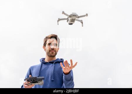 Young man operating a flying drone outdoors Stock Photo