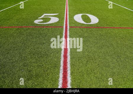 View of the 50 yard line on an American Football field with artificial turf Stock Photo