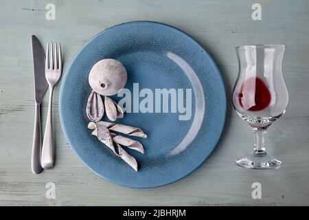Blue plate with glass of wine and exotic spices and fruits on light blue wooden table. Flat lay Stock Photo