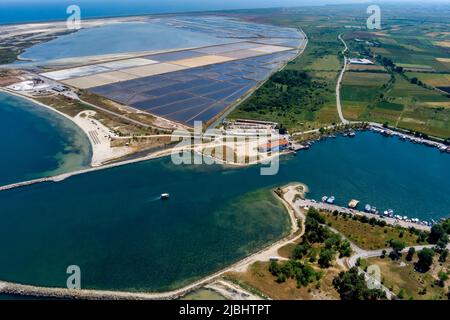 Aerial view of the port and the beach of Kitros Pieria and in the background salt evaporation ponds and salt mounds. Greece Stock Photo