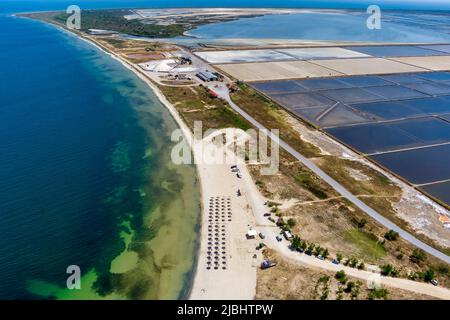 Aerial view of the port and the beach of Kitros Pieria and in the background salt evaporation ponds and salt mounds. Greece Stock Photo