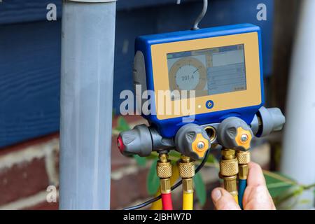 Technician is checking air conditioner with multimeter Stock Photo