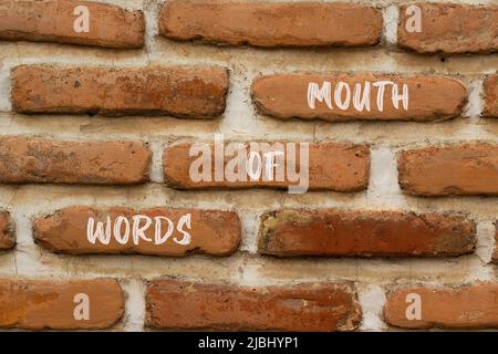 Words of mouth symbol. Concept words Words of mouth on red bricks on a beautiful brick wall background. Business, finacial and words of mouth concept. Stock Photo