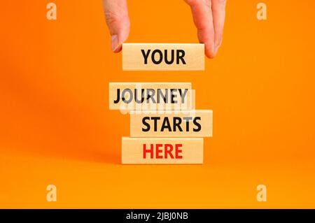 Your journey starts here symbol. Concept words Your journey starts here on wooden blocks on a beautiful orange table orange background. Business, moti Stock Photo