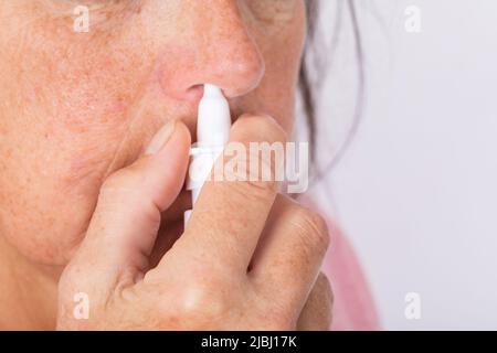 Close up of woman hands using nasal spray. Stock Photo